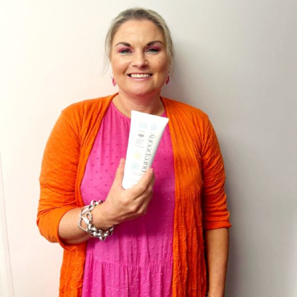 julie customer in bright colours holding peony moisturiser for dry and sensitive skin