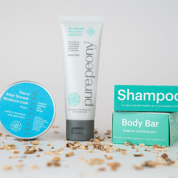 With root a Peony After Shower Lock in tin next to a 80ml tube of High Factor and the Shampoo Box sitting on top of the Body Bar box