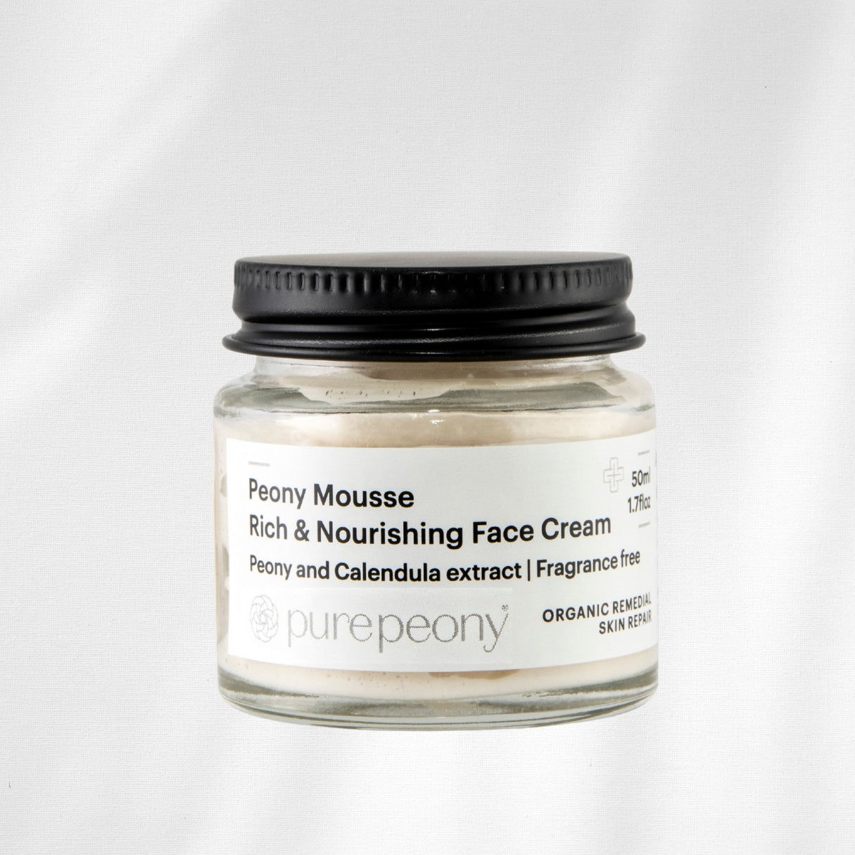 Jar of Peony Mousse Rich & Nourishing Face Cream with a black lid on a white background